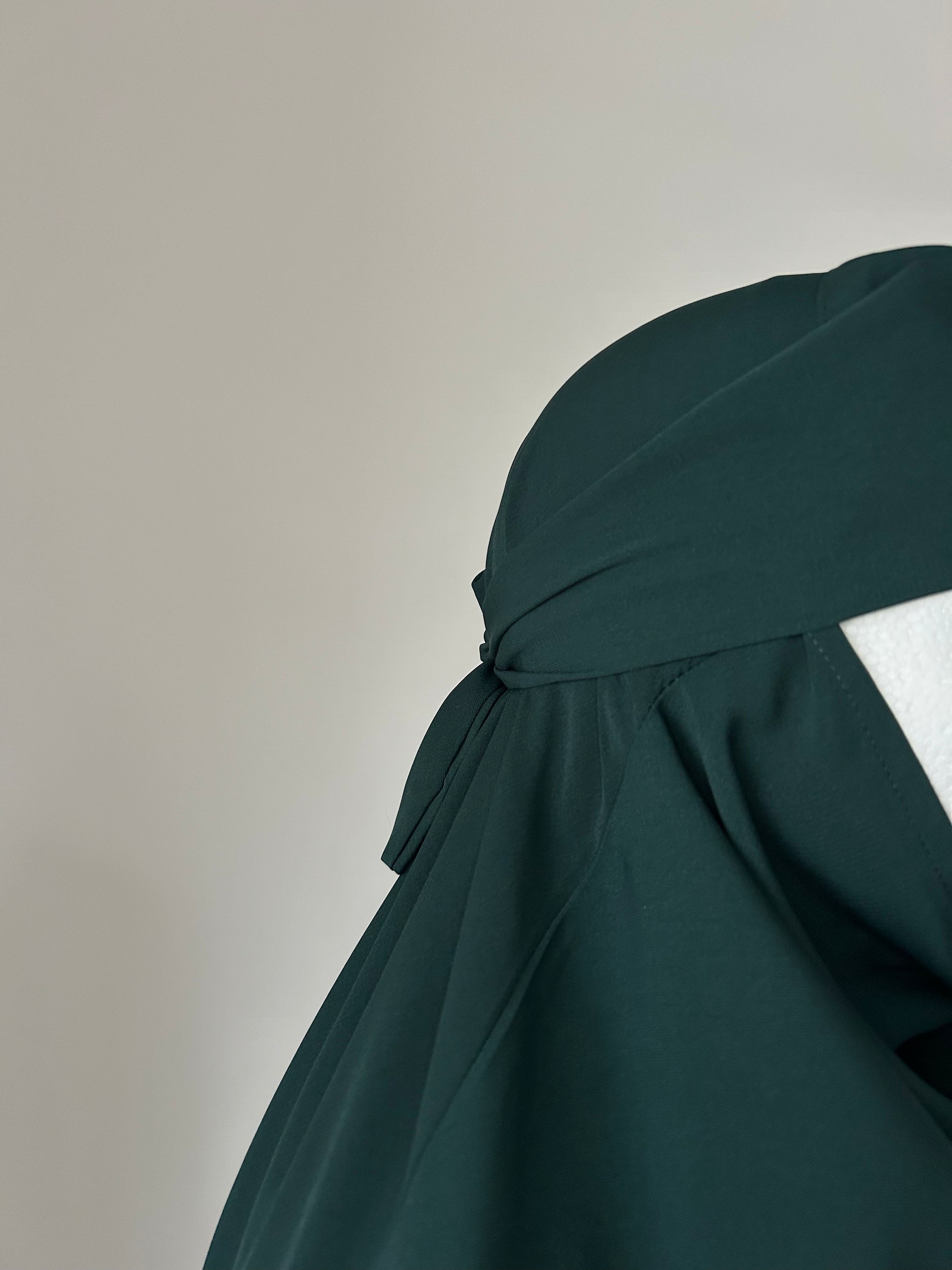 Side view of Deep Pine Layla Khimar, showcasing the elegant drape and flow of the single-layer design by Lipes Modest Wear.